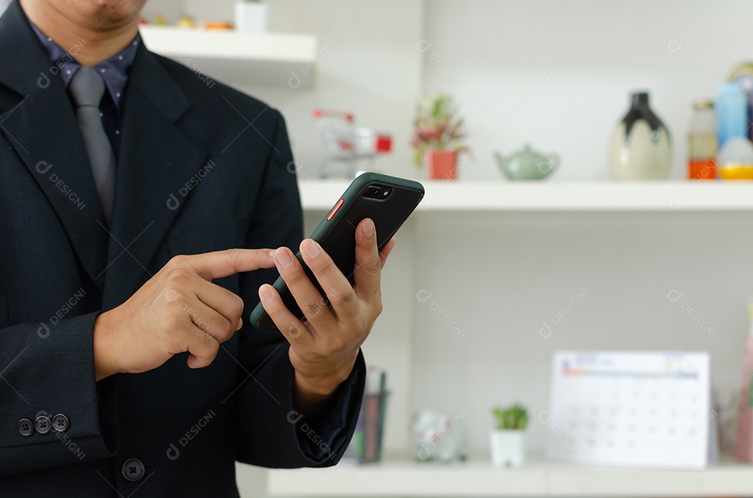 Empresário segurando o celular para comunicação empresarial ou marketing online.