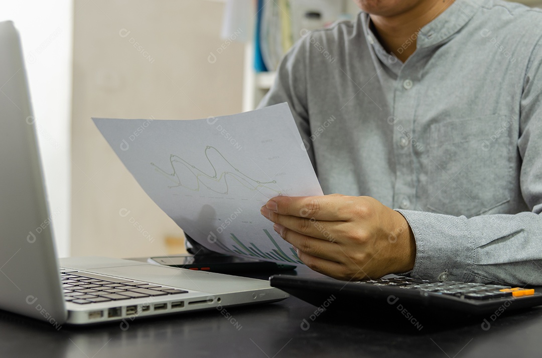 Homem de negócios usando calculadora em uma mesa. Conceitos de finanças, impostos e investimentos empresariais.