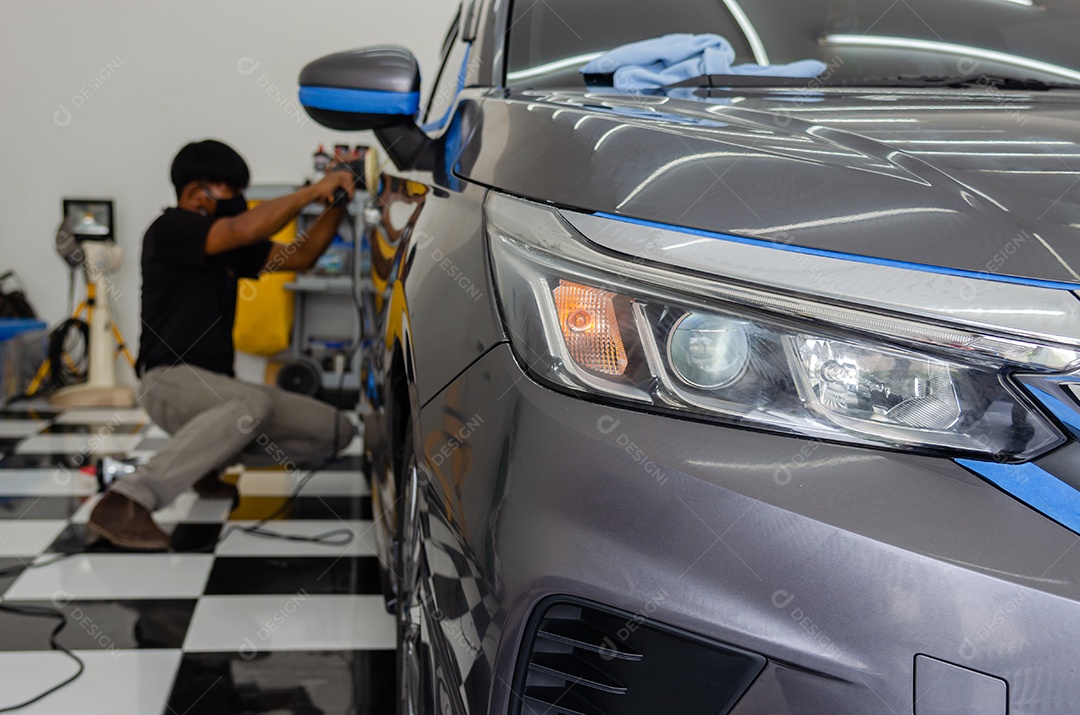 Detalhes do carro. Um mecânico masculino está aplicando um revestimento de vitrocerâmica no carro na oficina.