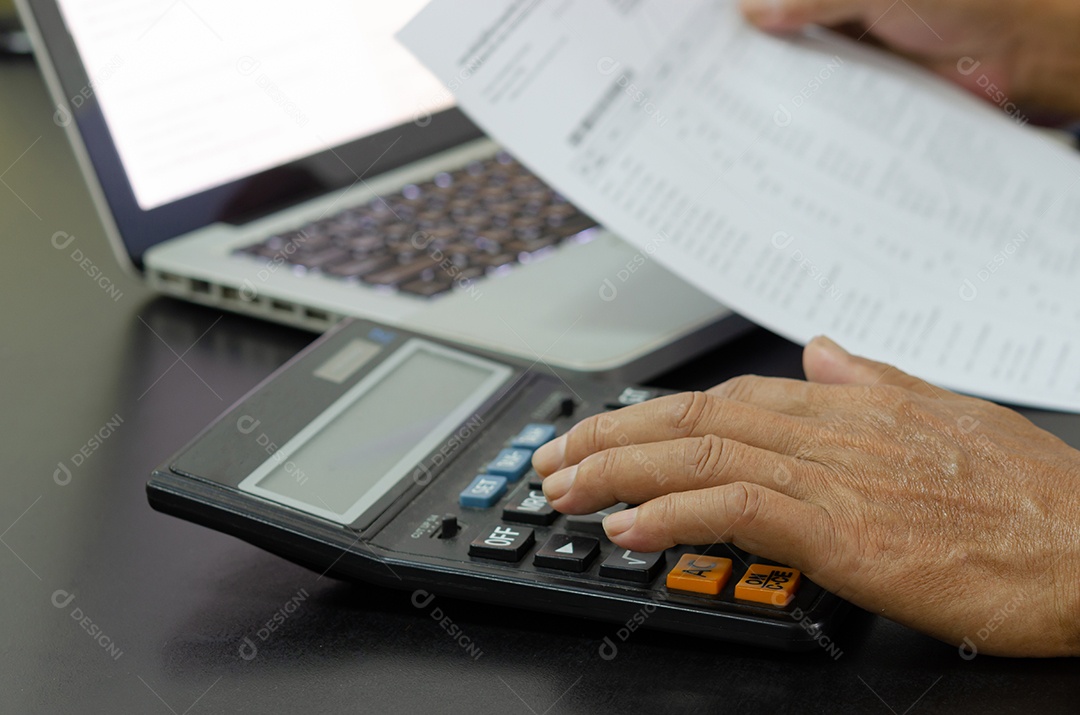 Homem de negócios usando calculadora em uma mesa. Conceitos de finanças, impostos e investimentos empresariais.