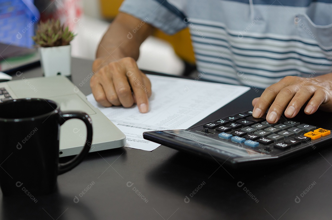 Homem de negócios usando calculadora em uma mesa. Conceitos de finanças, impostos e investimentos empresariais.