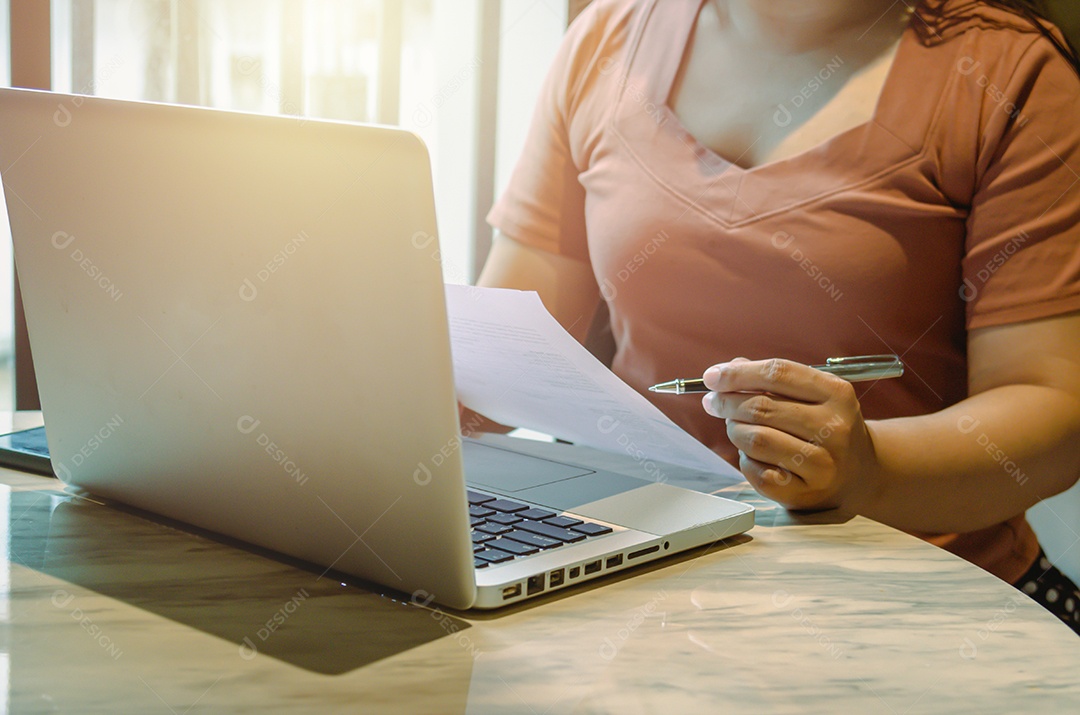 Mulher segurando canetas e documentos com um laptop em uma mesa, empresa, finanças, bancos ou impostos.