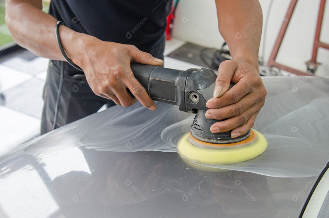 Homem trabalhando para polir, revestir carros.