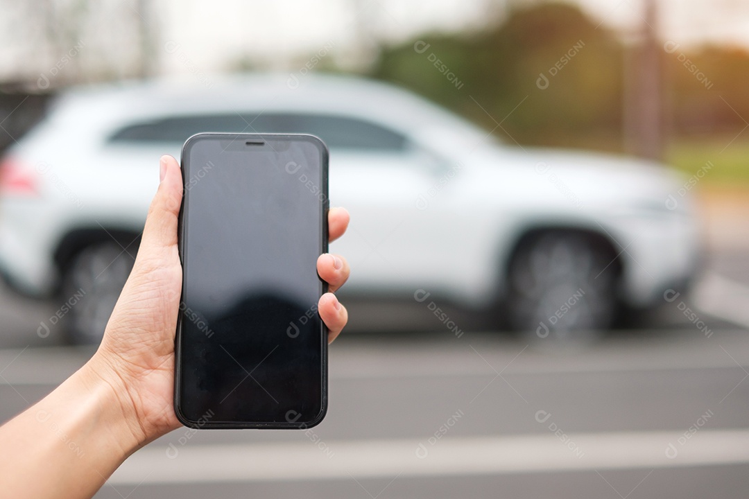 Mão segurando o controle remoto do carro, chave inteligente para bloquear ou desbloquear as portas do carro branco. Conceito de segurança, viagens e transporte