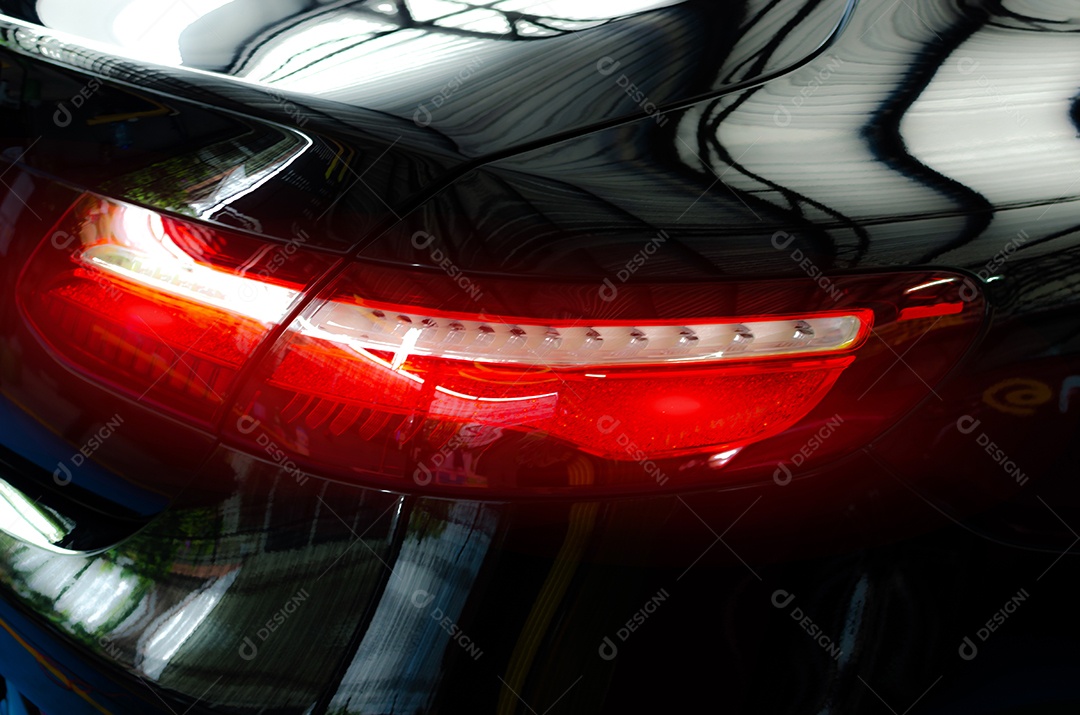 Luz traseira do carro de luxo em um fundo preto.