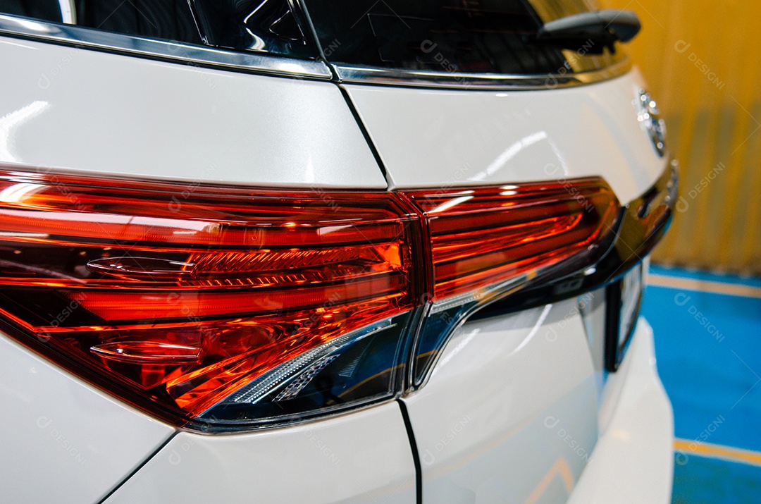 Perto das lanternas traseiras, carros brancos.