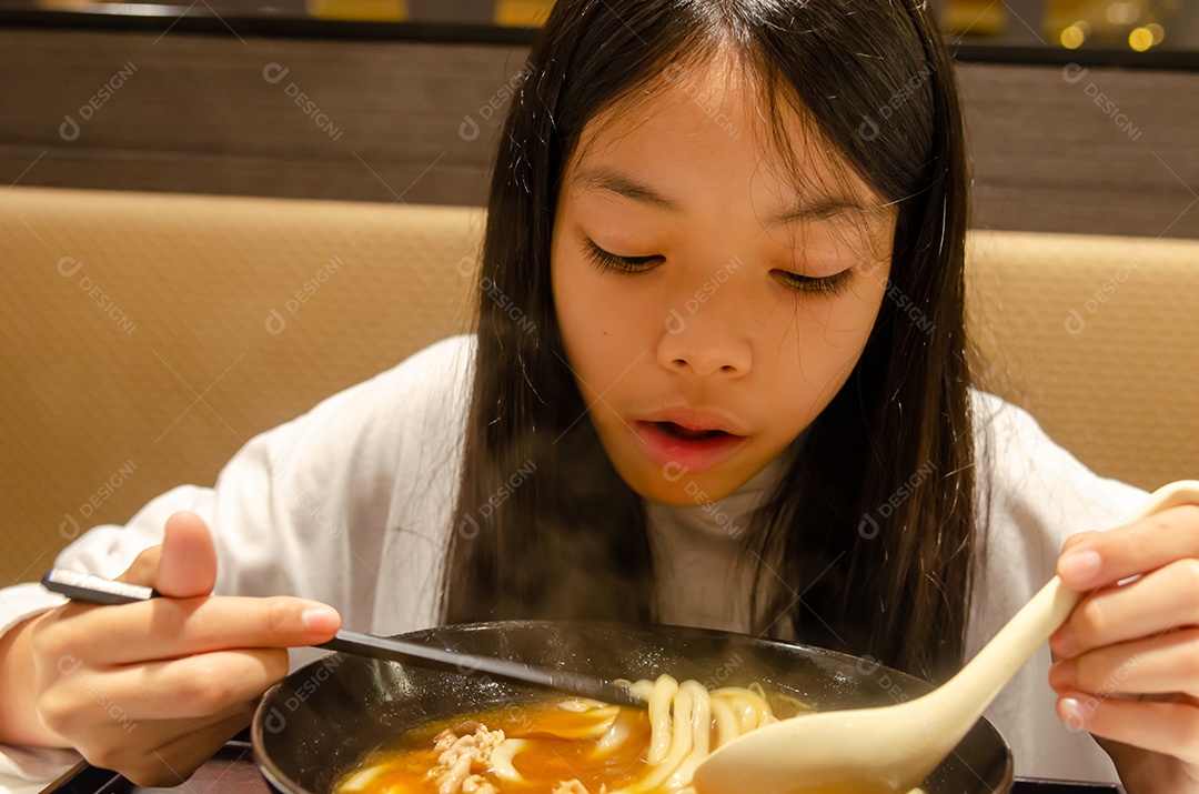Menina asiática comendo comida japonesa