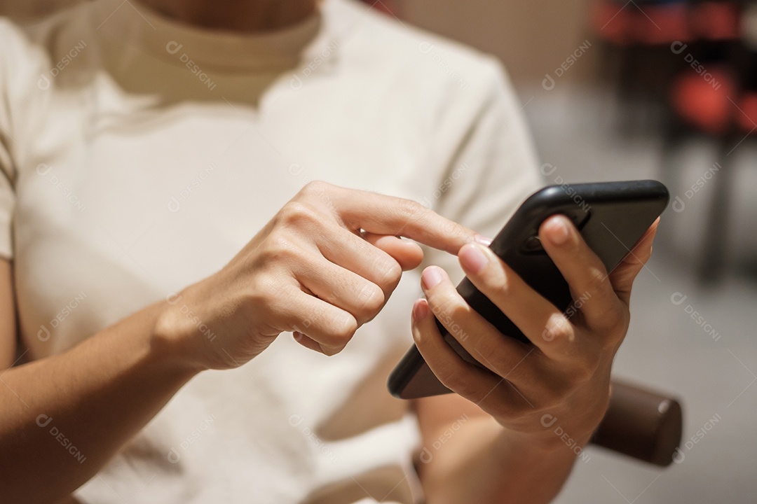 Mulher de negócios casual segurando e usando smartphone para mensagens sms, jovem digitando celular touchscreen no café ou escritório moderno. estilo de vida, tecnologia, mídia social e conceito de rede