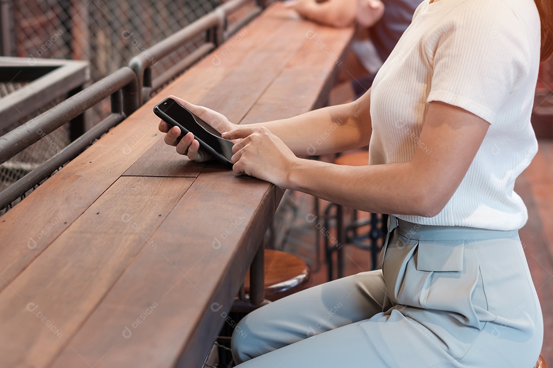 Mulher de negócios casual segurando e usando smartphone para mensagens sms, jovem digitando celular touchscreen no café ou escritório moderno. estilo de vida, tecnologia, mídia social e conceito de rede