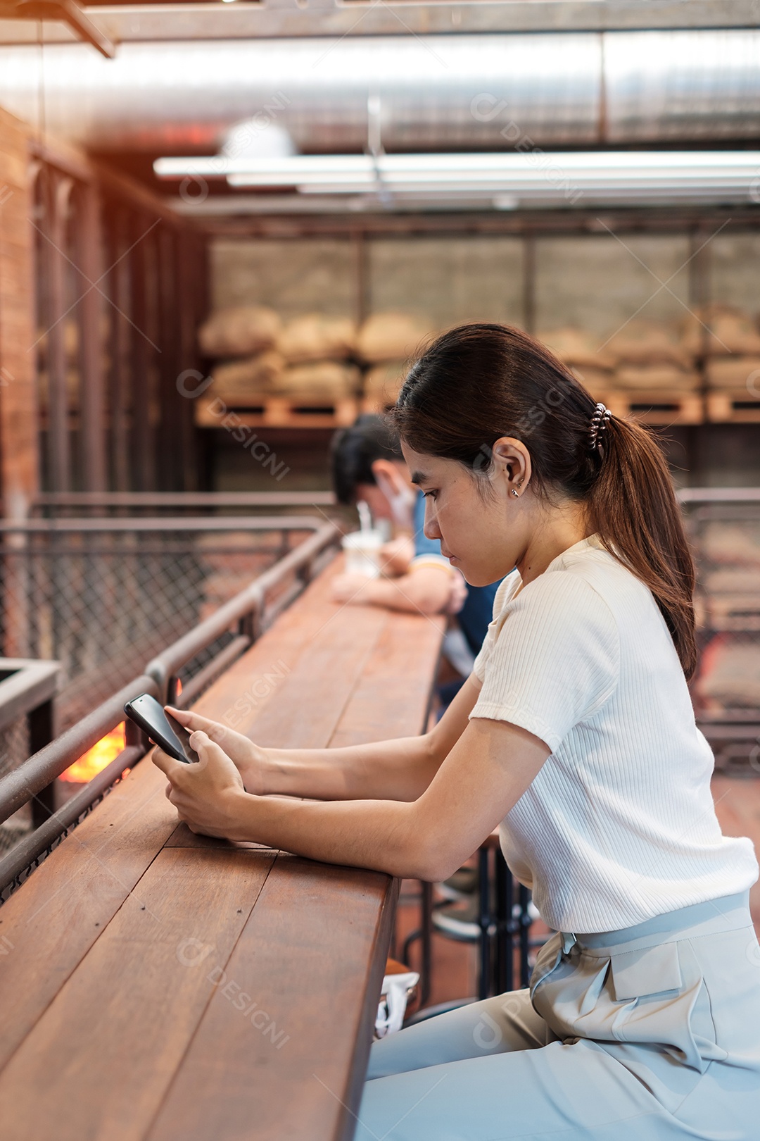 Casual business woman holding and using smartphone for sms messaging, young woman typing on touchscreen cell phone in cafe or modern office. lifestyle, technology, social media and networking concept