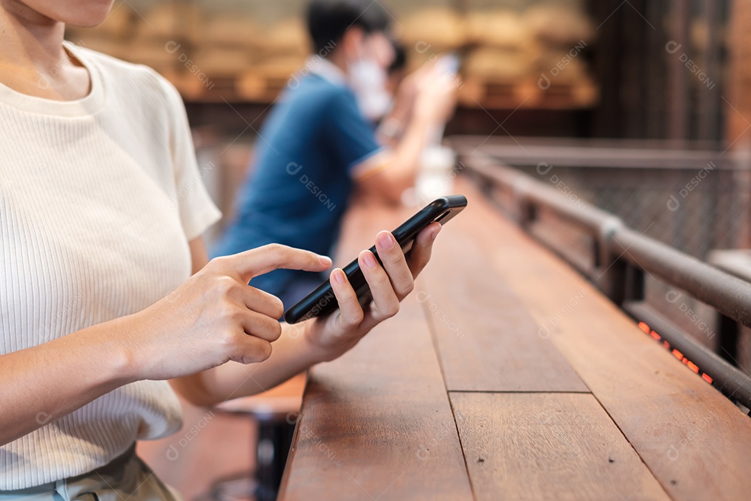 Mulher de negócios casual segurando e usando smartphone para mensagens sms, jovem digitando celular touchscreen no café ou escritório moderno. estilo de vida, tecnologia, mídia social e conceito de rede