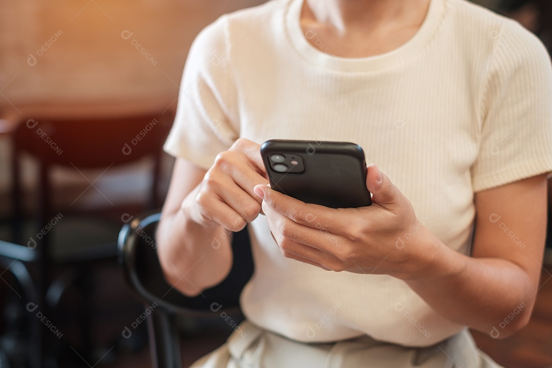 Mulher de negócios casual segurando e usando smartphone para mensagens sms, jovem digitando celular touchscreen no café ou escritório moderno. estilo de vida, tecnologia, mídia social e conceito de rede