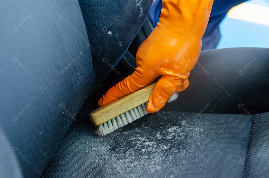 Homens usando luvas para pegar a escova de limpeza do assento do carro