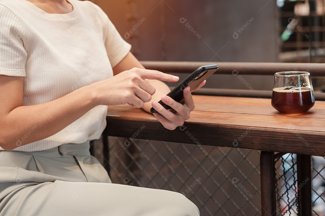 Mulher de negócios casual segurando e usando smartphone para mensagens sms, jovem digitando celular touchscreen no café ou escritório moderno. estilo de vida, tecnologia, mídia social e conceito de rede
