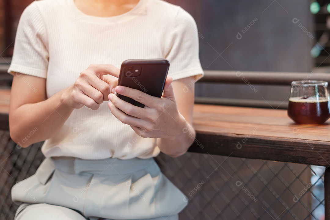 Mulher de negócios casual segurando e usando smartphone para mensagens sms, jovem digitando celular touchscreen no café ou escritório moderno. estilo de vida, tecnologia, mídia social e conceito de rede