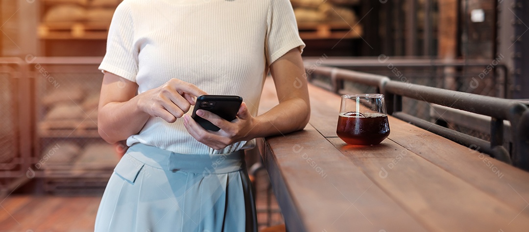 Mulher de negócios casual segurando e usando smartphone para mensagens sms, jovem digitando celular touchscreen no café ou escritório moderno. estilo de vida, tecnologia, mídia social e conceito de rede