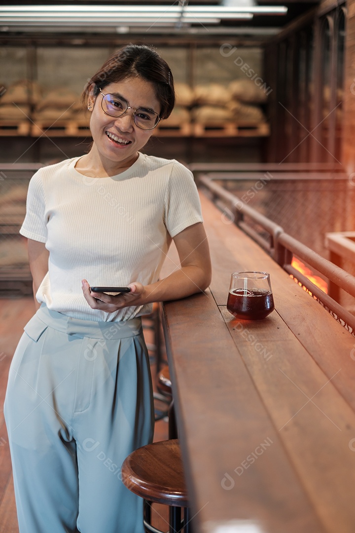 Mulher de negócios casual segurando e usando smartphone para mensagens sms, jovem digitando celular touchscreen no café ou escritório moderno. estilo de vida, tecnologia, mídia social e conceito de rede