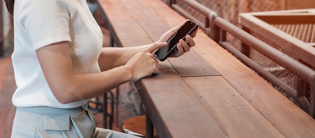 Mulher de negócios casual segurando e usando smartphone para mensagens sms, jovem digitando celular touchscreen no café ou escritório moderno. estilo de vida, tecnologia, mídia social e conceito de rede