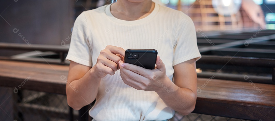 Mulher de negócios casual segurando e usando smartphone para mensagens sms, jovem digitando celular touchscreen no café ou escritório moderno. estilo de vida, tecnologia, mídia social e conceito de rede