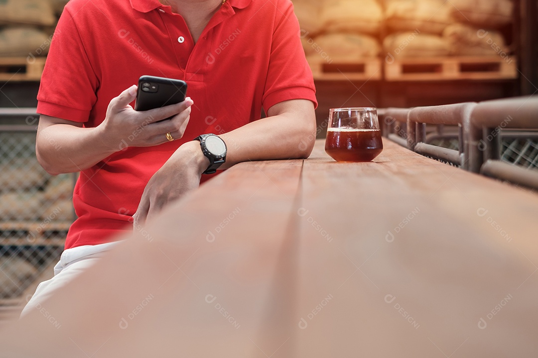 Empresário casual segurando e usando smartphone para mensagens sms, jovem digitando celular touchscreen no café ou escritório moderno. estilo de vida, tecnologia, mídia social e conceito de rede