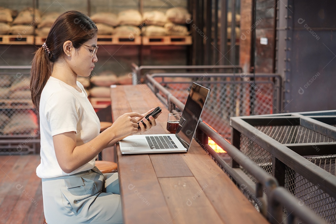 Mulher de negócios casual usando smartphone e laptop, mulher freelance digitando notebook de computador de teclado no café ou escritório moderno. tecnologia, digital online e conceito de rede