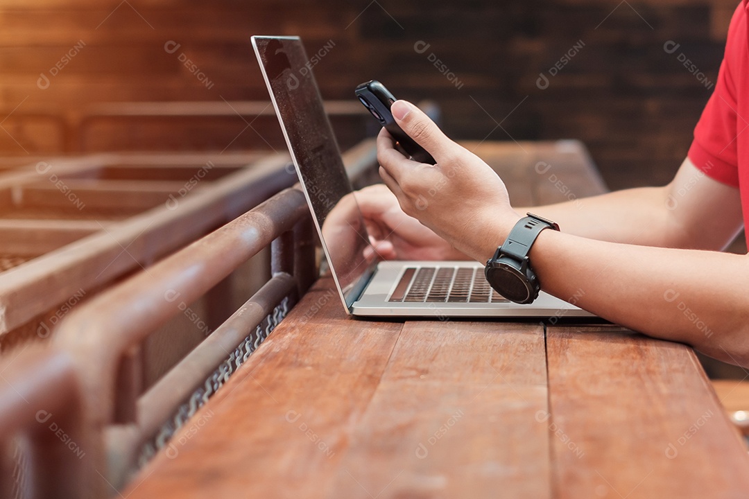 Empresário casual usando smartphone e laptop, homem freelance digitando notebook computador teclado no café ou escritório moderno. tecnologia, digital online e conceito de rede