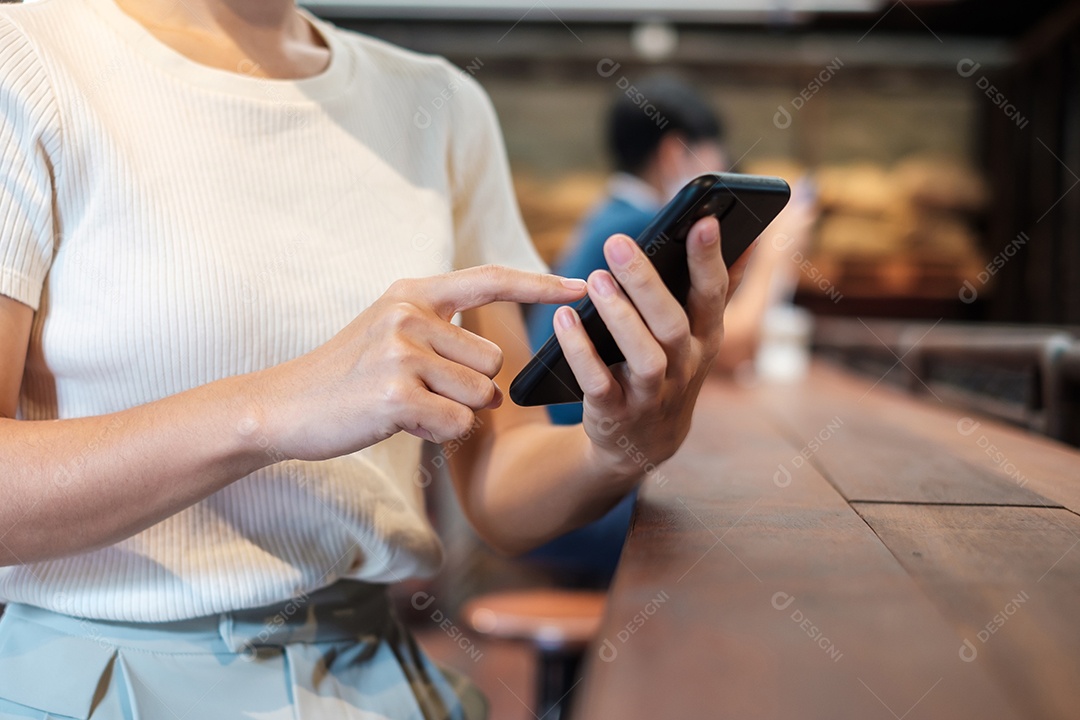 Mulher de negócios casual segurando e usando smartphone para mensagens sms, jovem digitando celular touchscreen no café ou escritório moderno. estilo de vida, tecnologia, mídia social e conceito de rede