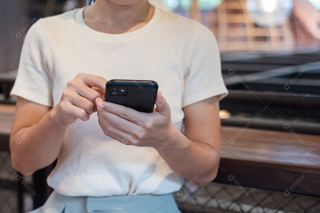 Mulher de negócios casual segurando e usando smartphone para mensagens sms, jovem digitando celular touchscreen no café ou escritório moderno. estilo de vida, tecnologia, mídia social e conceito de rede