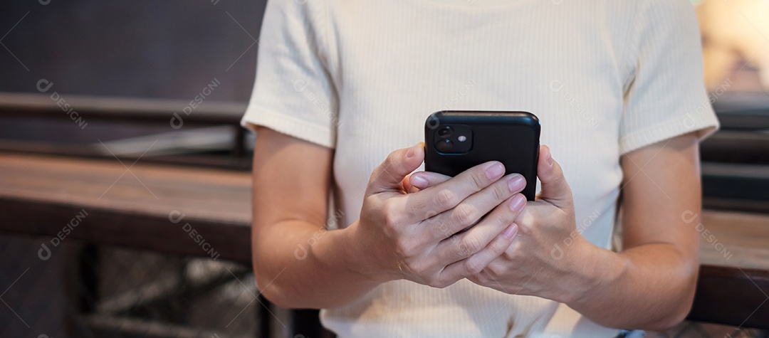 Mulher de negócios casual segurando e usando smartphone para mensagens sms, jovem digitando celular touchscreen no café ou escritório moderno. estilo de vida, tecnologia, mídia social e conceito de rede