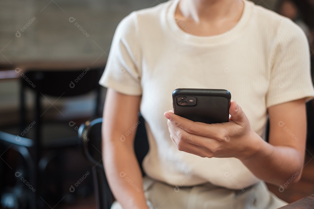 Mulher de negócios casual segurando e usando smartphone para mensagens sms, jovem digitando celular touchscreen no café ou escritório moderno. estilo de vida, tecnologia, mídia social e conceito de rede