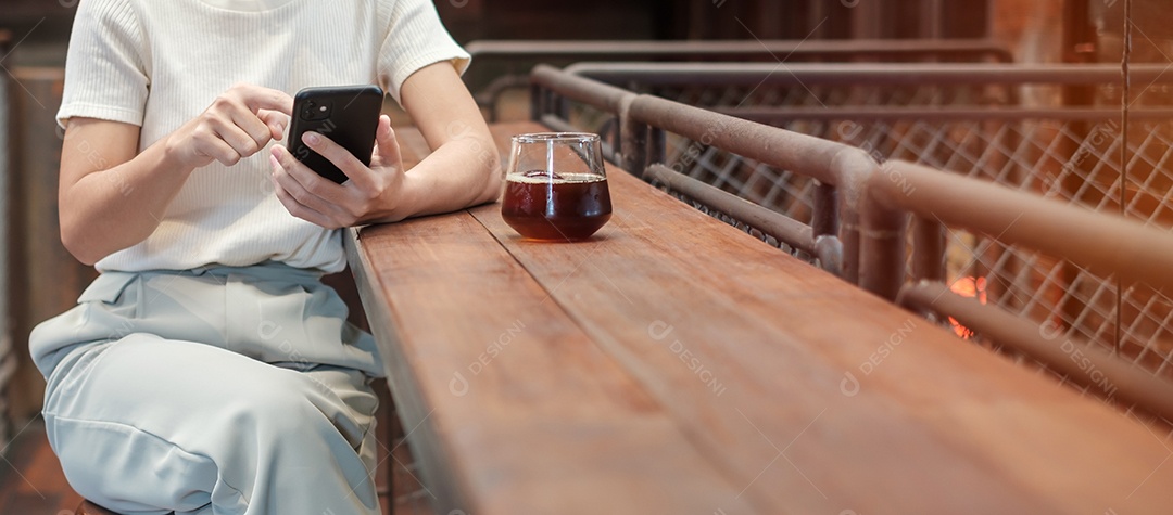 Mulher de negócios casual segurando e usando smartphone para mensagens sms, jovem digitando celular touchscreen no café ou escritório