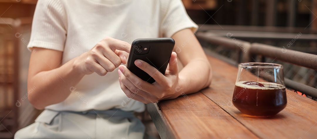 Casual businesswoman holding and using smartphone for sms messaging, young woman typing on touchscreen cell phone in cafe or office