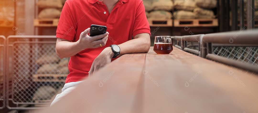 Empresário casual segurando e usando smartphone para mensagens sms, jovem digitando celular touchscreen no café ou escritório moderno. estilo de vida, tecnologia, mídia social e conceito de rede