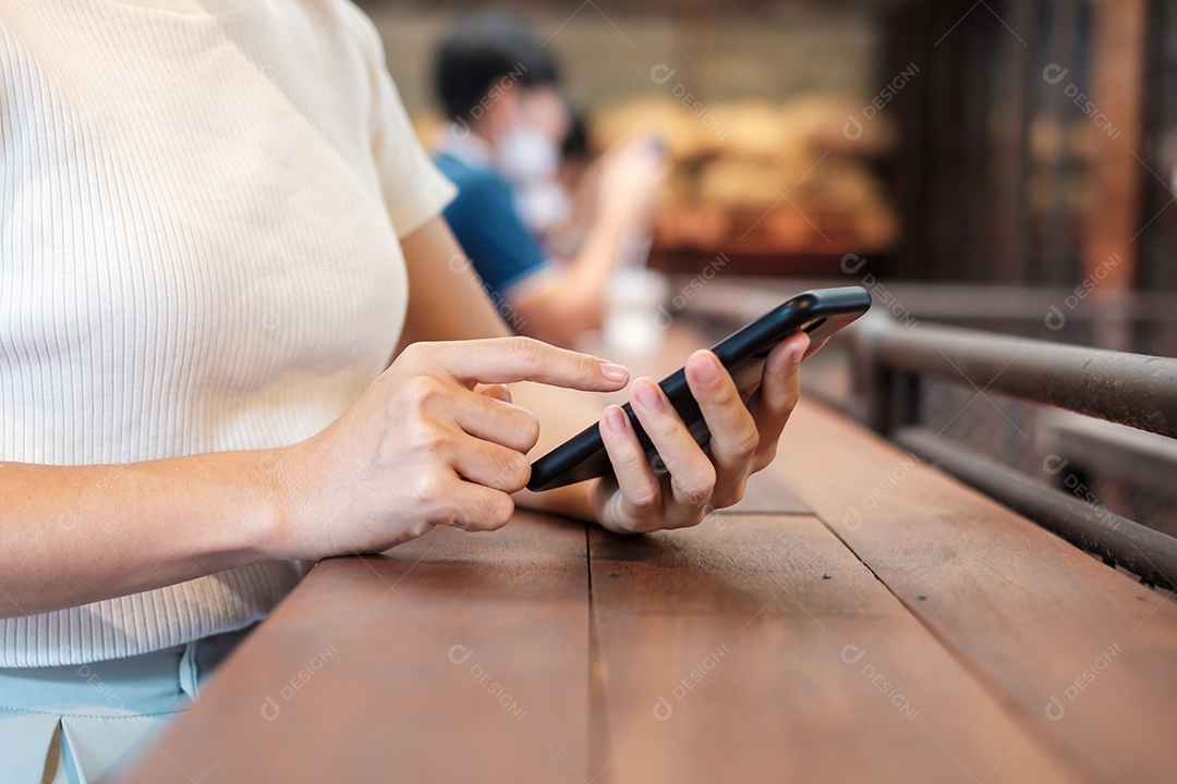 Mulher de negócios casual segurando e usando smartphone para mensagens sms, jovem digitando celular touchscreen no café ou escritório moderno. estilo de vida, tecnologia, mídia social e conceito de rede