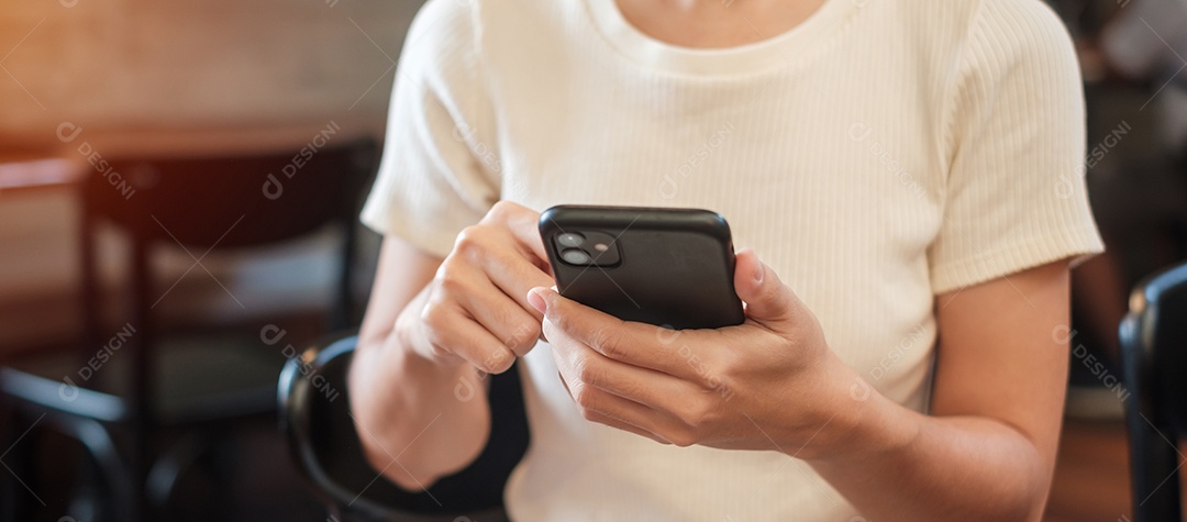 Mulher de negócios casual segurando e usando smartphone para mensagens sms, jovem digitando celular touchscreen no café ou escritório moderno. estilo de vida, tecnologia, mídia social e conceito de rede