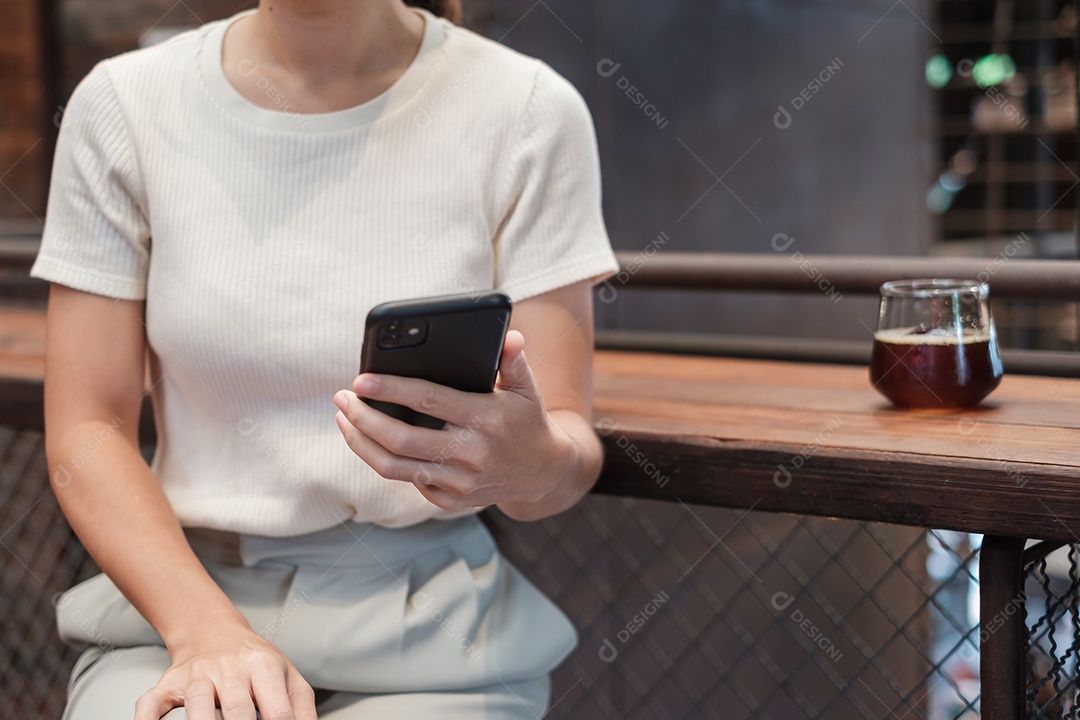 Mulher de negócios casual segurando e usando smartphone para mensagens sms, jovem digitando celular touchscreen no café ou escritório