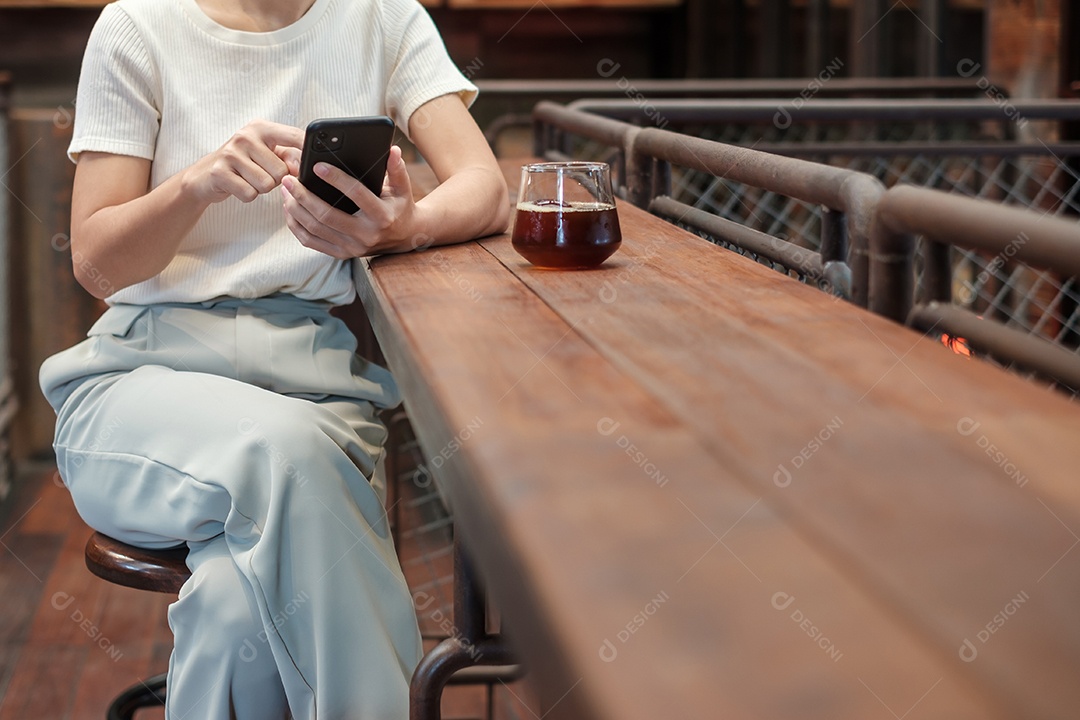 Mulher de negócios casual segurando e usando smartphone para mensagens sms, jovem digitando celular touchscreen no café ou escritório