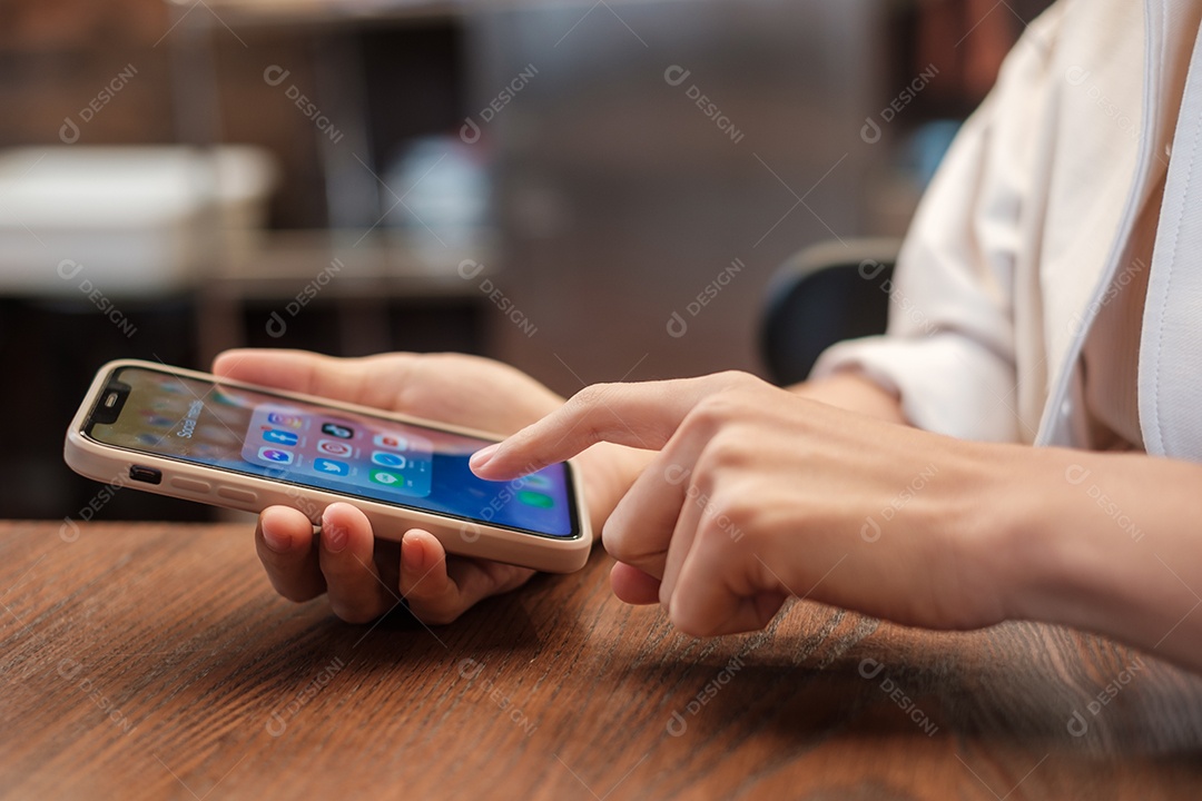 Bangkok, Tailândia mão usando Iphone com aplicativos de mídia social