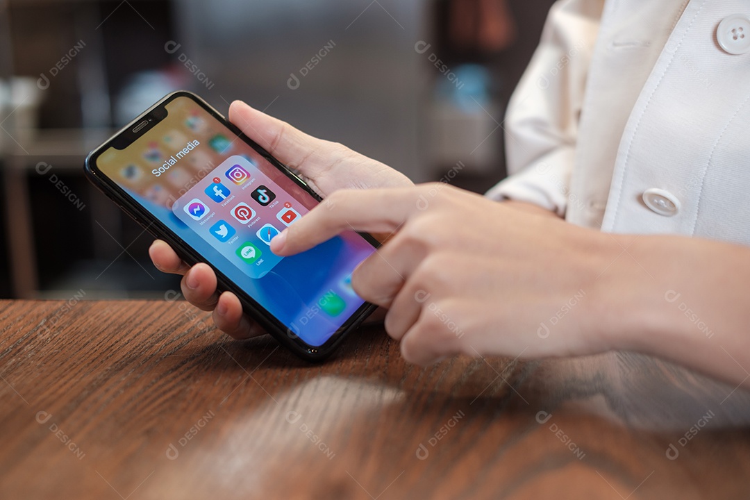 Bangkok, Tailândia mão usando Iphone com aplicativos de mídia social