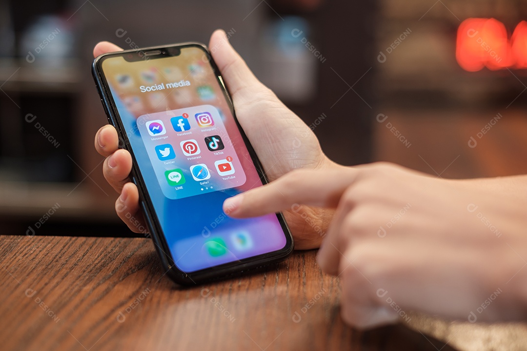 Bangkok, Tailândia mão usando Iphone com aplicativos de mídia social