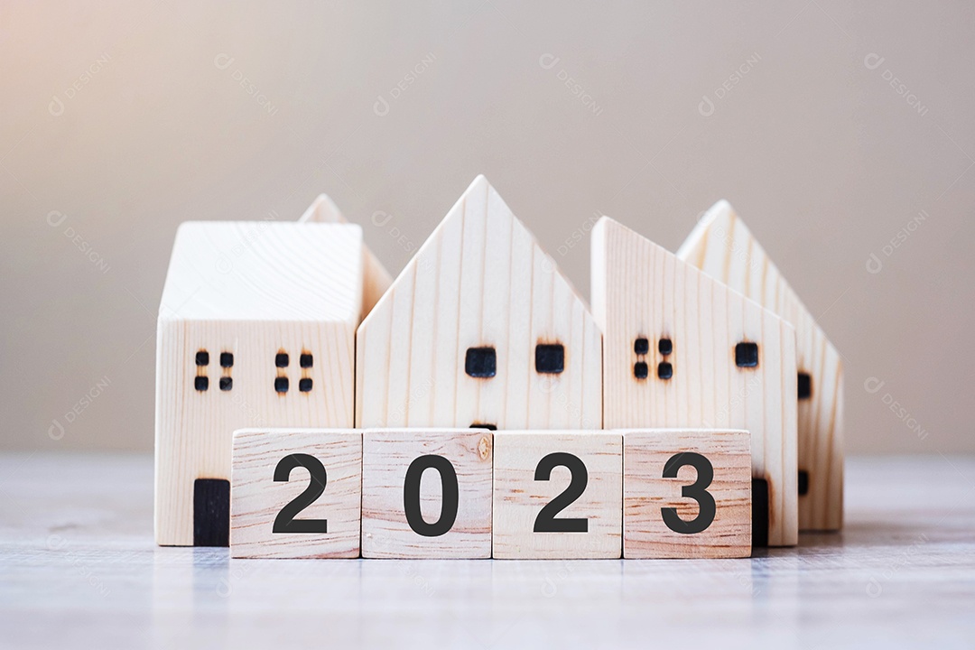 2023 feliz ano novo com modelo de casa no fundo de madeira da mesa. Conceitos bancários, imobiliários, de investimento, financeiros, de poupança e de resolução de ano novo