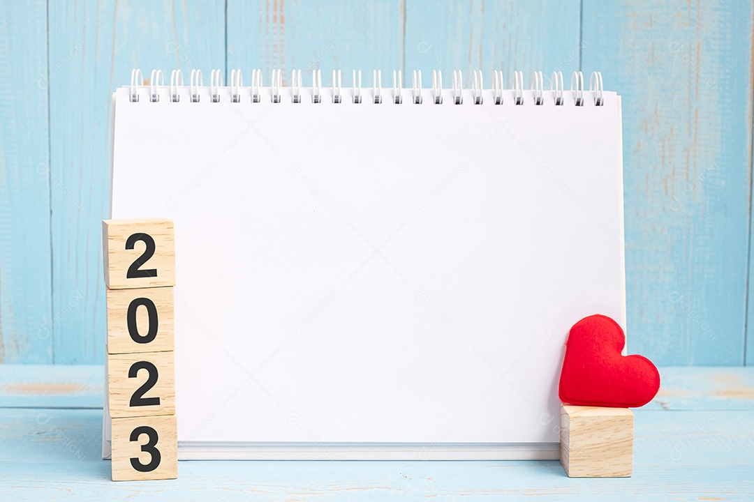 caderno em branco e cubos de 2023 com decoração em forma de coração vermelho no fundo da mesa de madeira azul. Ano Novo NovoVocê, Objetivo, Resolução, Saúde, Amor e Feliz Dia dos Namorados conceito