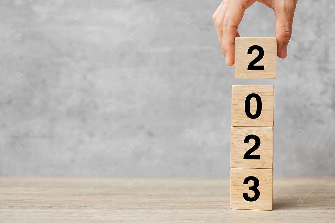 mão segurando o texto do bloco 2023 na mesa. Resolução, estratégia, plano, objetivo, motivação, reinicialização, negócios e conceitos de férias de ano novo