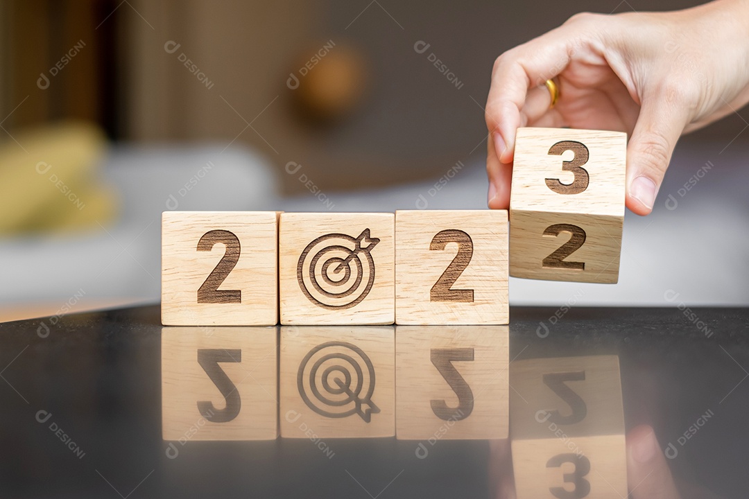 mão flip bloco 2022 a 2023 com sinal de alvo. Objetivo de negócios, alvo, resolução, estratégia, plano, motivação de ação, mudança, pensamento, contagem regressiva e conceitos de início de ano novo