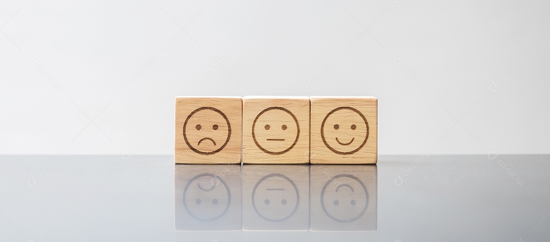 Mão de homem segurando o bloco de rosto de emoção. O cliente escolhe o Emoticon para comentários de usuários