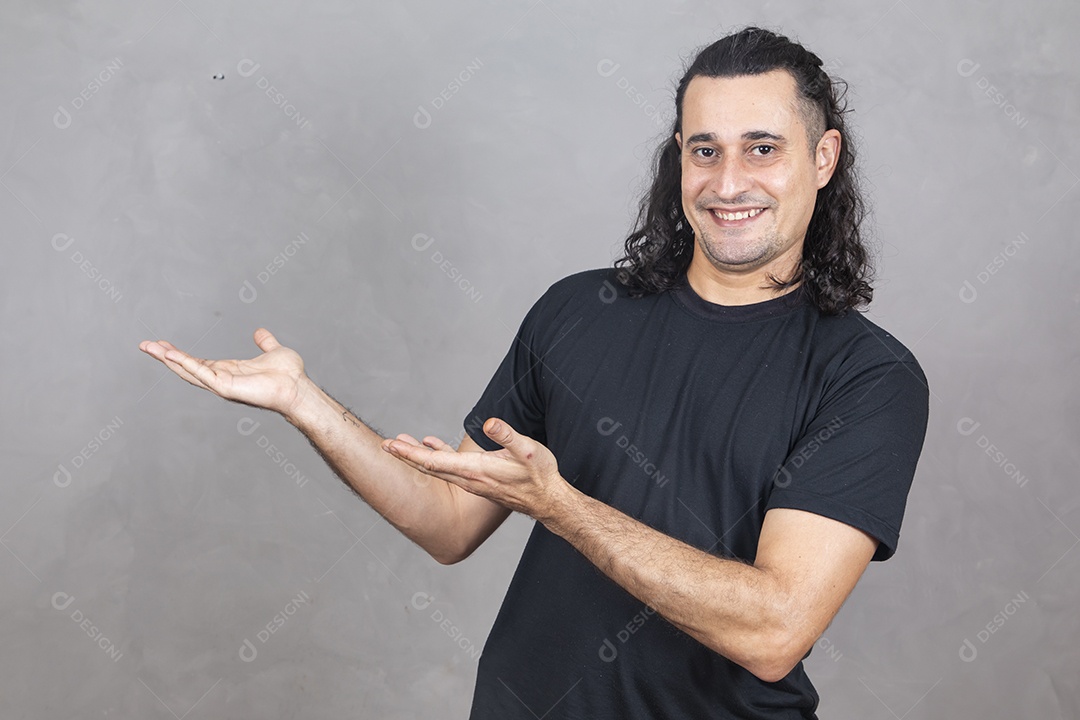 Homem jovem garoto sorridente apontando para lado sobre fundo isolado cinza