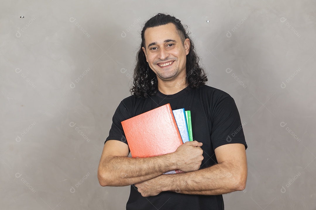 Homem jovem estudante segurando material escolar