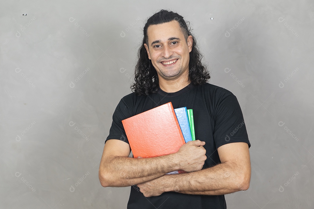 Homem jovem estudante segurando material escolar