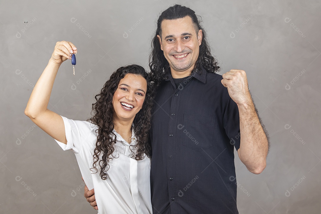 Casal apaixonados segurando chave de carro Conceito conquista automóvel sobre fundo isolado cinza