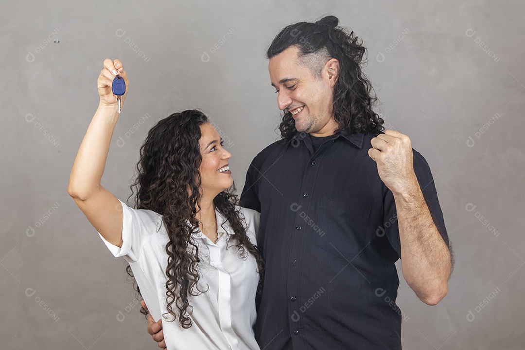 Casal apaixonados segurando chave de carro Conceito conquista automóvel sobre fundo isolado cinza